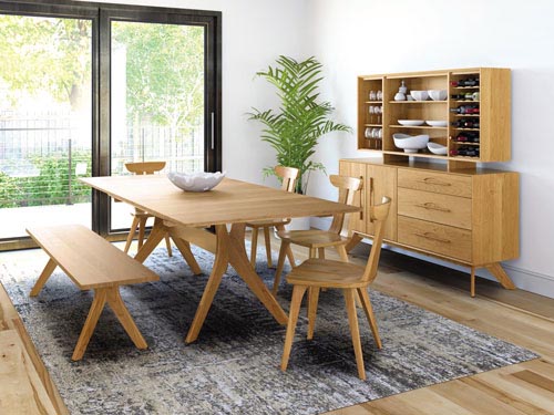 rectangular wooden dining table by COPELAND with chairs and bench