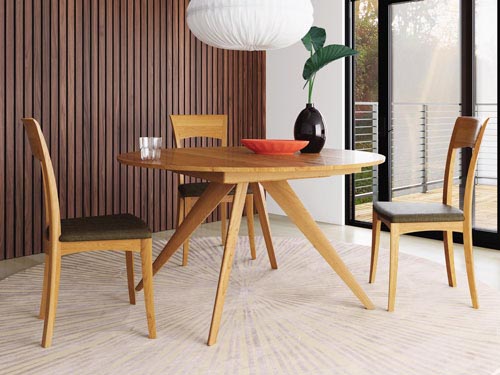 round wooden dining table by COPELAND with chairs
