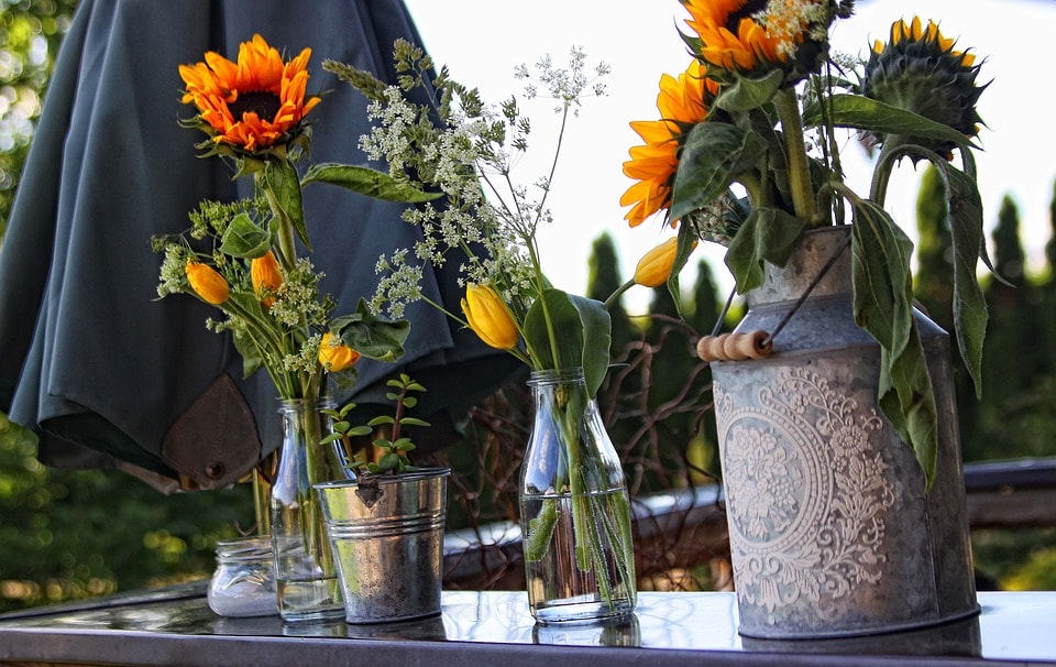 fresh orange and yellow sunflowers and tulips in vases